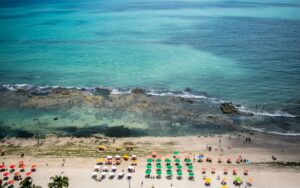 Vista aérea da praia de Boa Viagem com guarda-sóis coloridos e mar